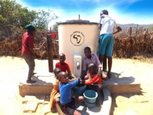 Group of children with water pump installed by The Africa Trust