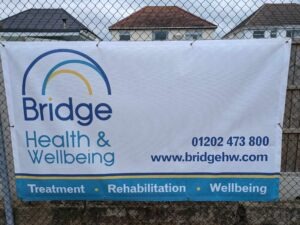 Bridge Health & Wellbeing sponsorship banner at Christchurch Tennis Club